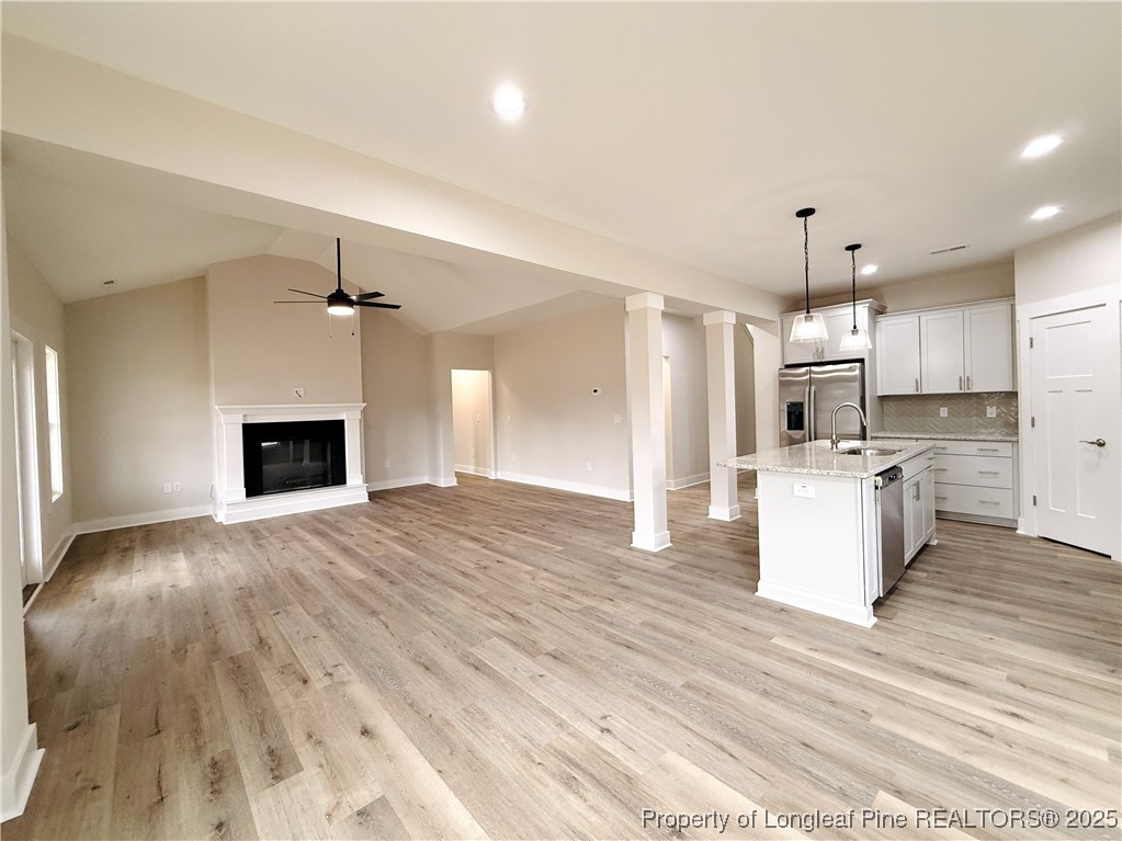 279 Elijah Way Vass, NC 28394 - Photo 13 of 36 a view of kitchen and empty room with wooden floor