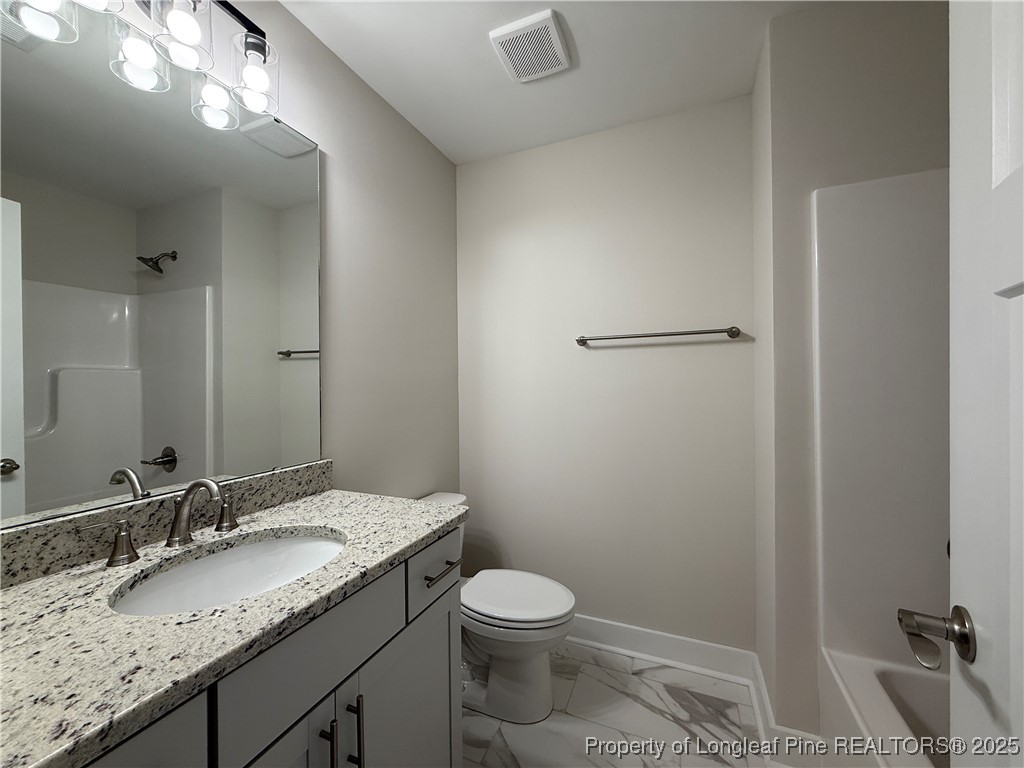 279 Elijah Way Vass, NC 28394 - Photo 33 of 36 a bathroom with a granite countertop sink toilet and shower