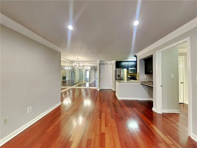a view of a big room with wooden floor and windows