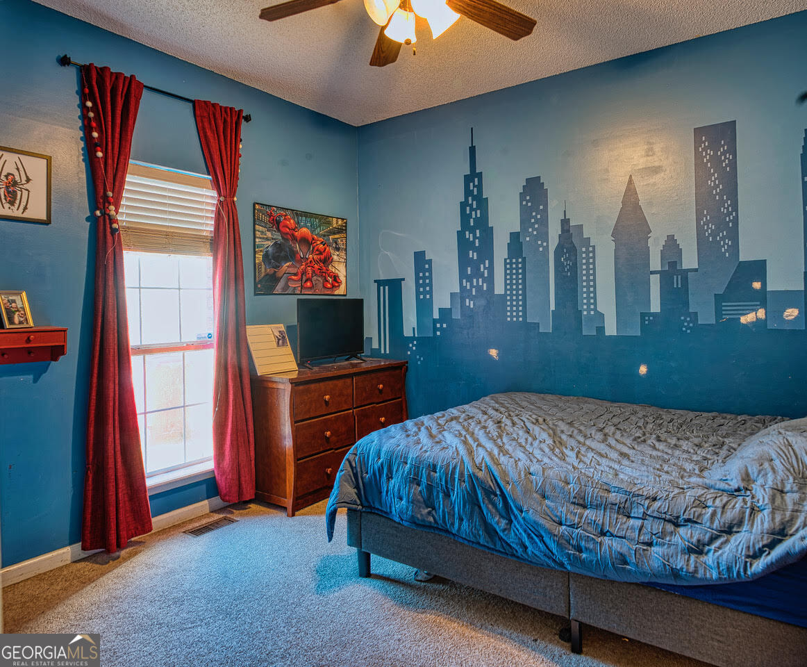 221 Pendleton Court Macon, GA 31216 - Photo 16 of 16 a bedroom with a bed and a flat tv screen on dresser