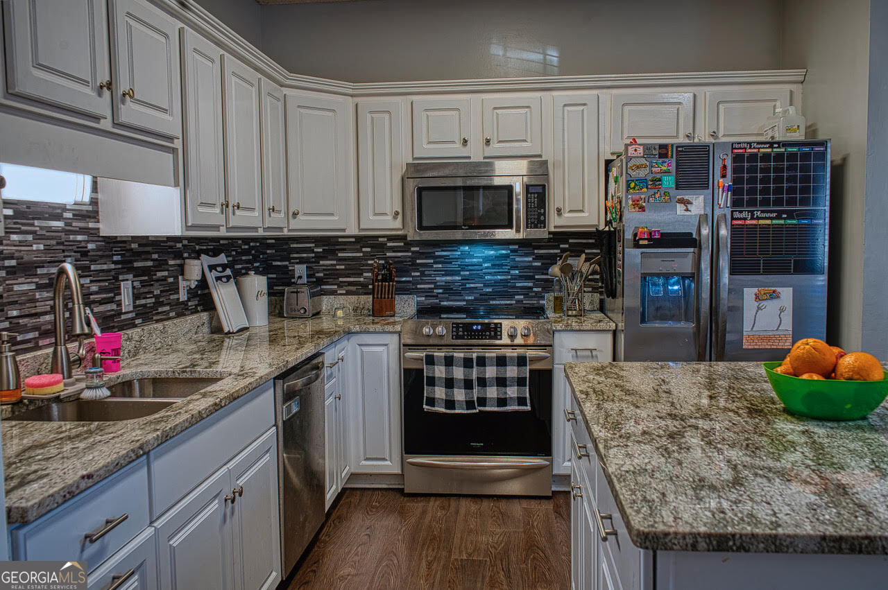 221 Pendleton Court Macon, GA 31216 - Photo 6 of 16 a kitchen with stainless steel appliances granite countertop a stove and cabinets