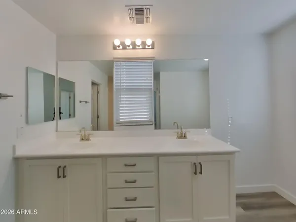 an empty room with chandelier fan and windows