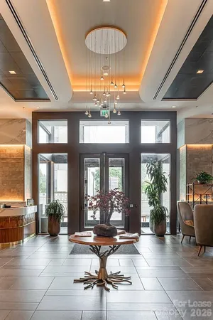 a living room with furniture a chandelier and a large window