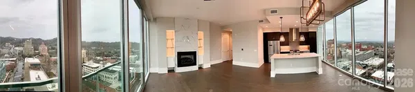 a view of a hallway with wooden floor and windows