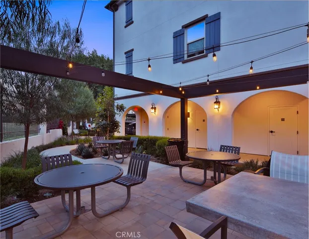 an empty room with wooden floor chandelier and windows