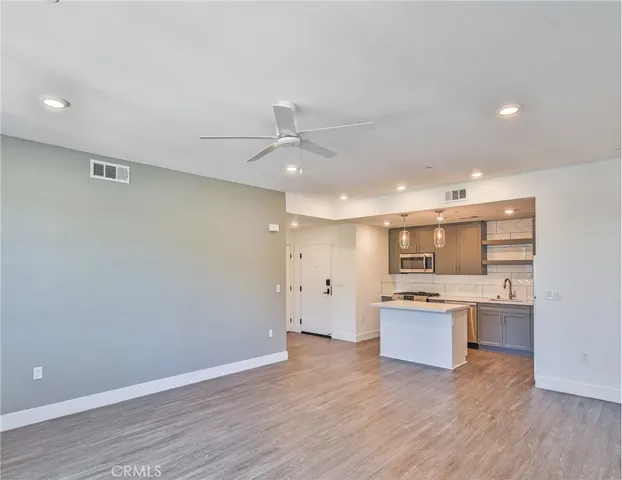 a kitchen with kitchen island a sink a stove a refrigerator and cabinets