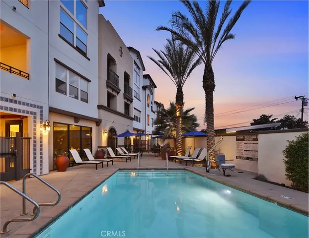 a view of a swimming pool with a lounge chair and palm trees
