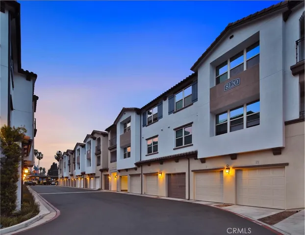 a front view of residential houses with yard and street view