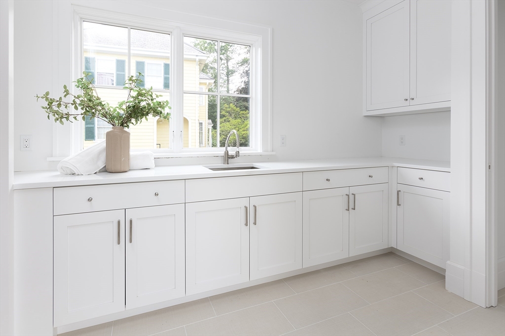 68 Clyde Street Brookline, MA 02445 - Photo 21 of 25 a kitchen with white cabinets and a window