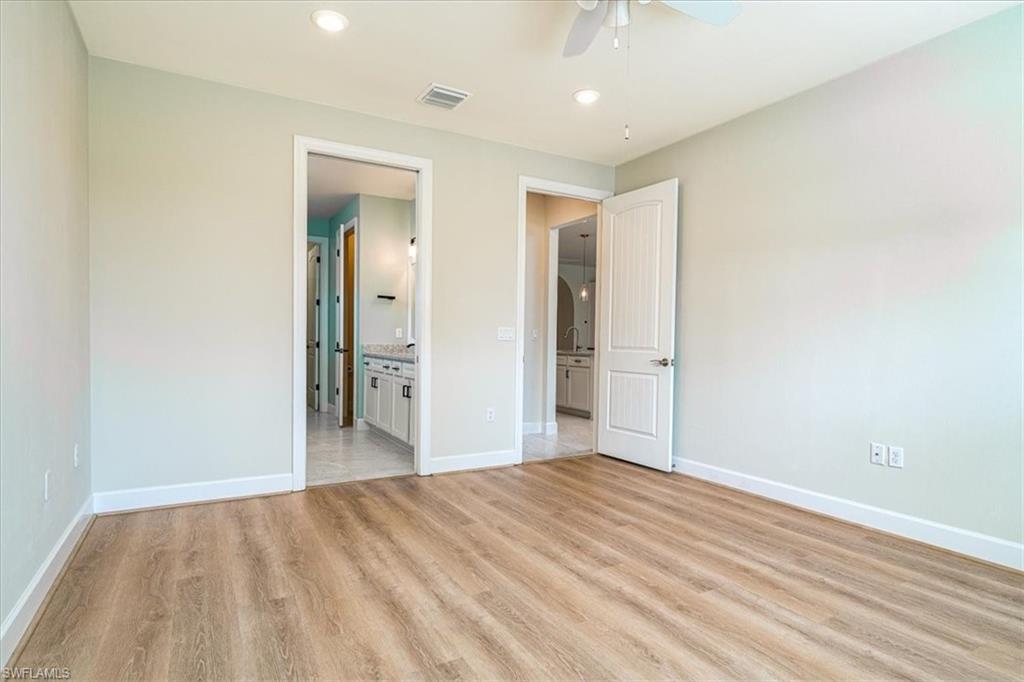 1996 Parson Street Naples, FL 34120 - Photo 30 of 50 Unfurnished bedroom with recessed lighting, light wood-style flooring, a ceiling fan, and ensuite bathroom