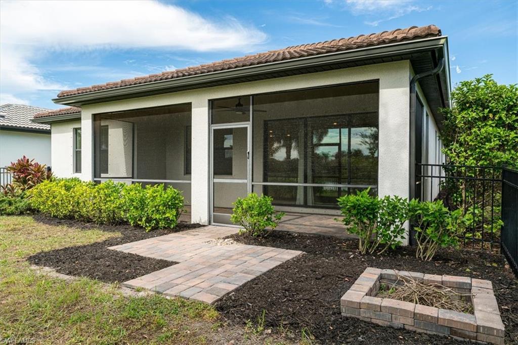 1996 Parson Street Naples, FL 34120 - Photo 35 of 50 Back of house featuring a sunroom, a tile roof, and stucco siding