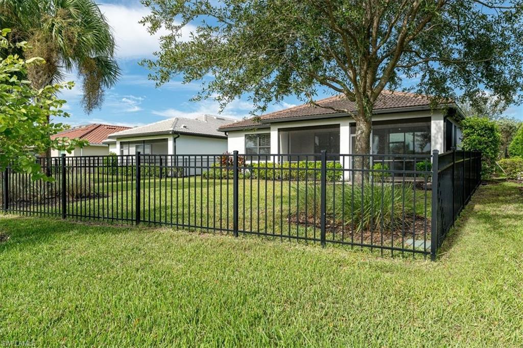 1996 Parson Street Naples, FL 34120 - Photo 40 of 50 Back of property with a tiled roof, stucco siding, a sunroom, and a garage