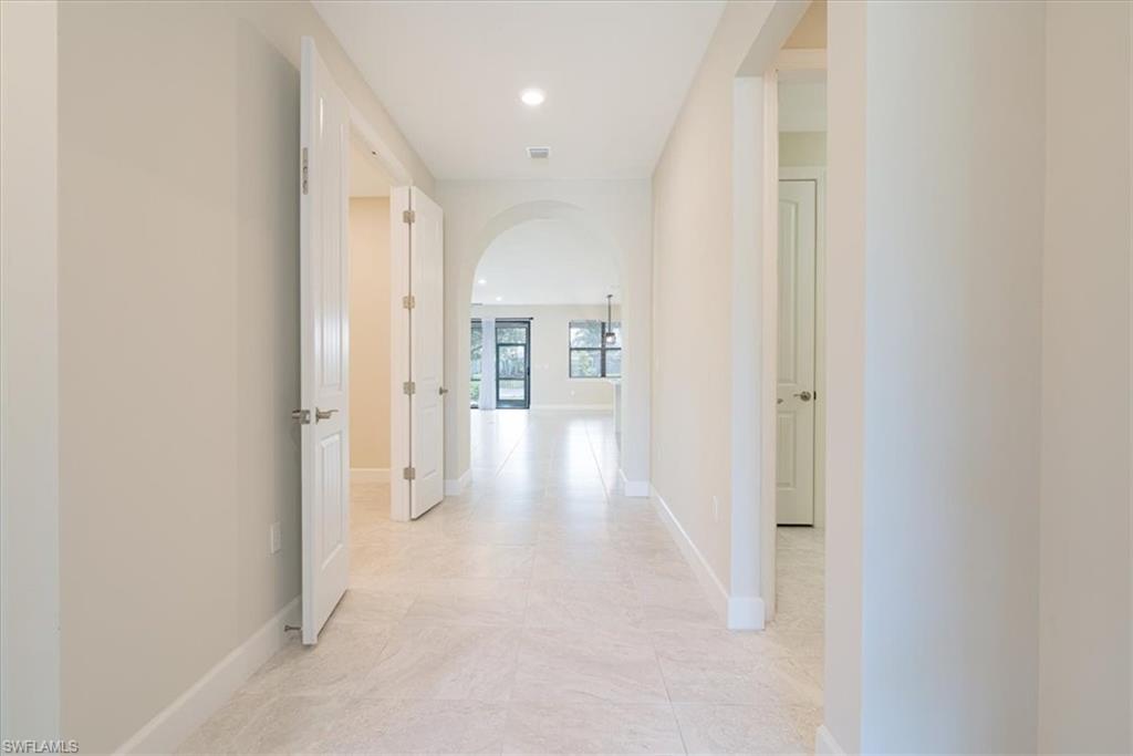 1996 Parson Street Naples, FL 34120 - Photo 6 of 50 Hallway with arched walkways, recessed lighting, and light tile patterned floors