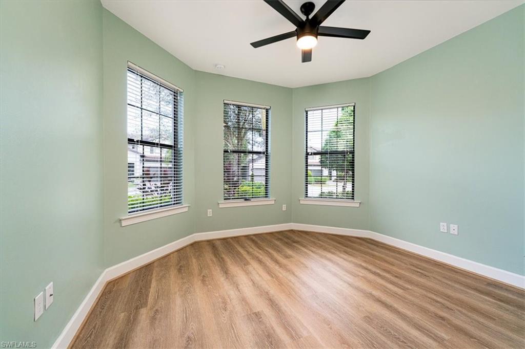 1996 Parson Street Naples, FL 34120 - Photo 7 of 50 Empty room featuring healthy amount of natural light, wood finished floors, and a ceiling fan