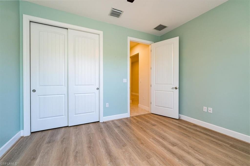 1996 Parson Street Naples, FL 34120 - Photo 8 of 50 Unfurnished bedroom featuring wood finished floors and a closet