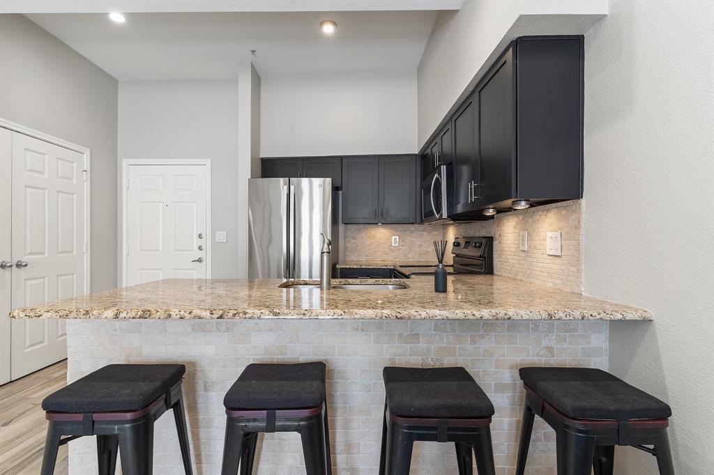 3102 Kings Road, Unit 1106 Dallas, TX 75219 - Photo 7 of 20 a kitchen with stainless steel appliances granite countertop a sink and cabinets
