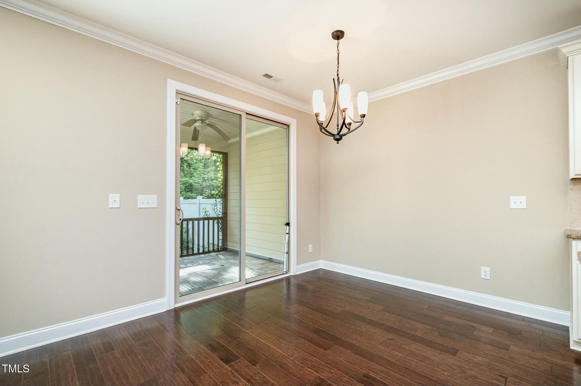 1335 Catch Fly Lane Durham, NC 27713 - Photo 11 of 30 a view of a chandelier in an empty room with wooden floor and a window