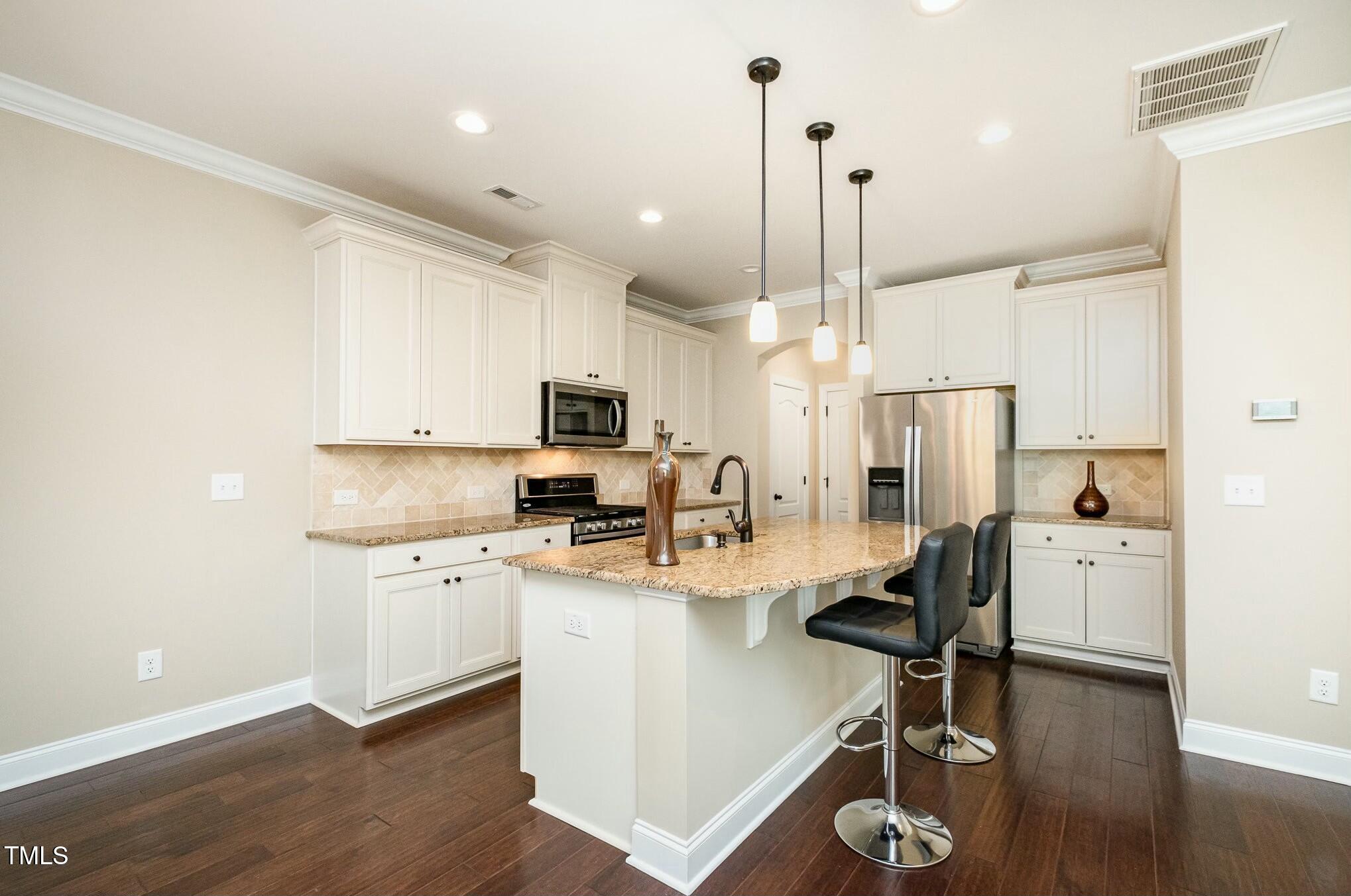 1335 Catch Fly Lane Durham, NC 27713 - Photo 12 of 30 a kitchen with stainless steel appliances kitchen island a refrigerator a stove a sink and a chairs