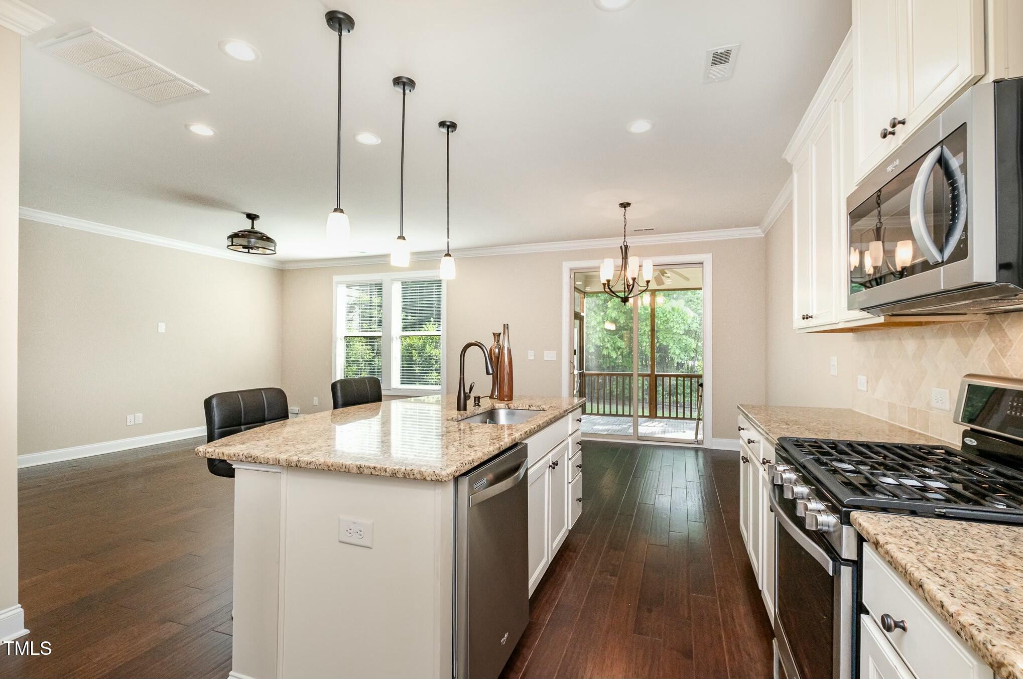 1335 Catch Fly Lane Durham, NC 27713 - Photo 14 of 30 a kitchen with stainless steel appliances granite countertop a stove a sink and a wooden floors