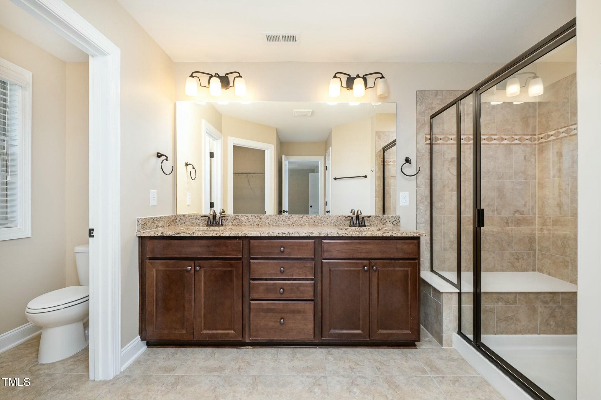 1335 Catch Fly Lane Durham, NC 27713 - Photo 17 of 30 a spacious bathroom with a granite countertop sink toilet mirror and bathtub