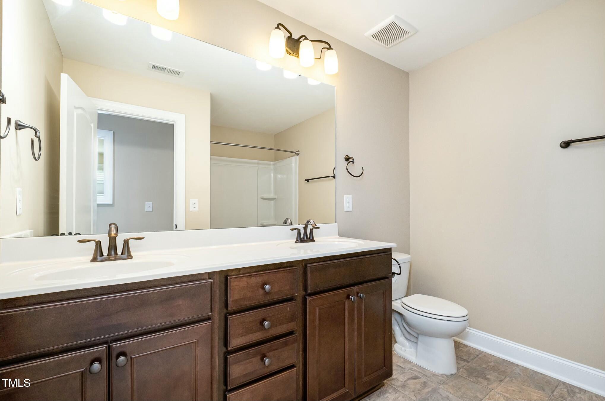 1335 Catch Fly Lane Durham, NC 27713 - Photo 22 of 30 a bathroom with a toilet sink and mirror