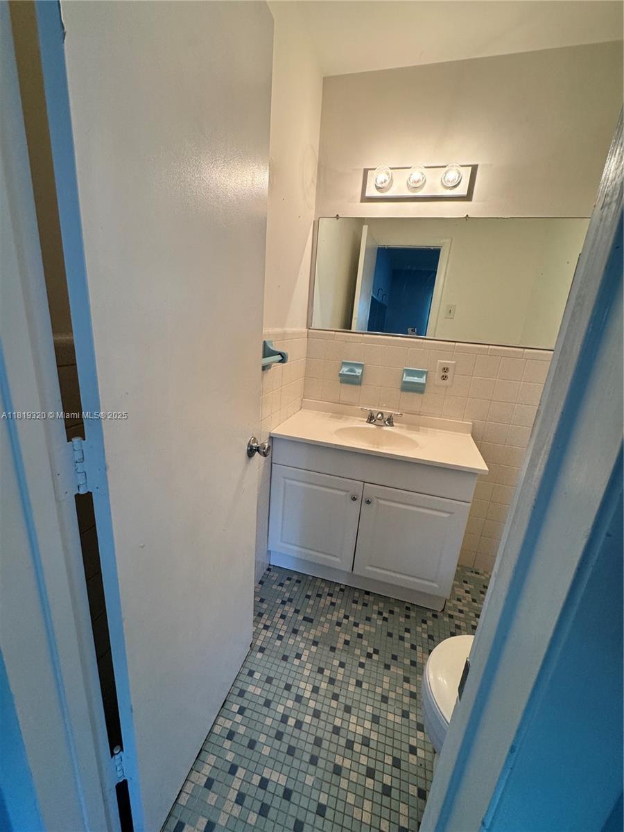 2701 Northeast 1st Street, Unit 203 Pompano Beach, FL 33062 - Photo 12 of 16 a bathroom with a sink and a mirror
