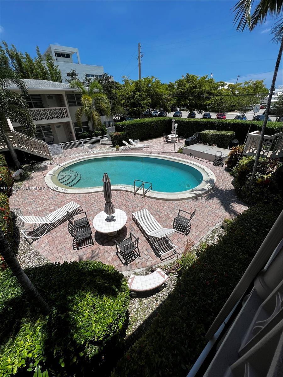 2701 Northeast 1st Street, Unit 203 Pompano Beach, FL 33062 - Photo 3 of 16 a view of a swimming pool with outdoor seating and plants