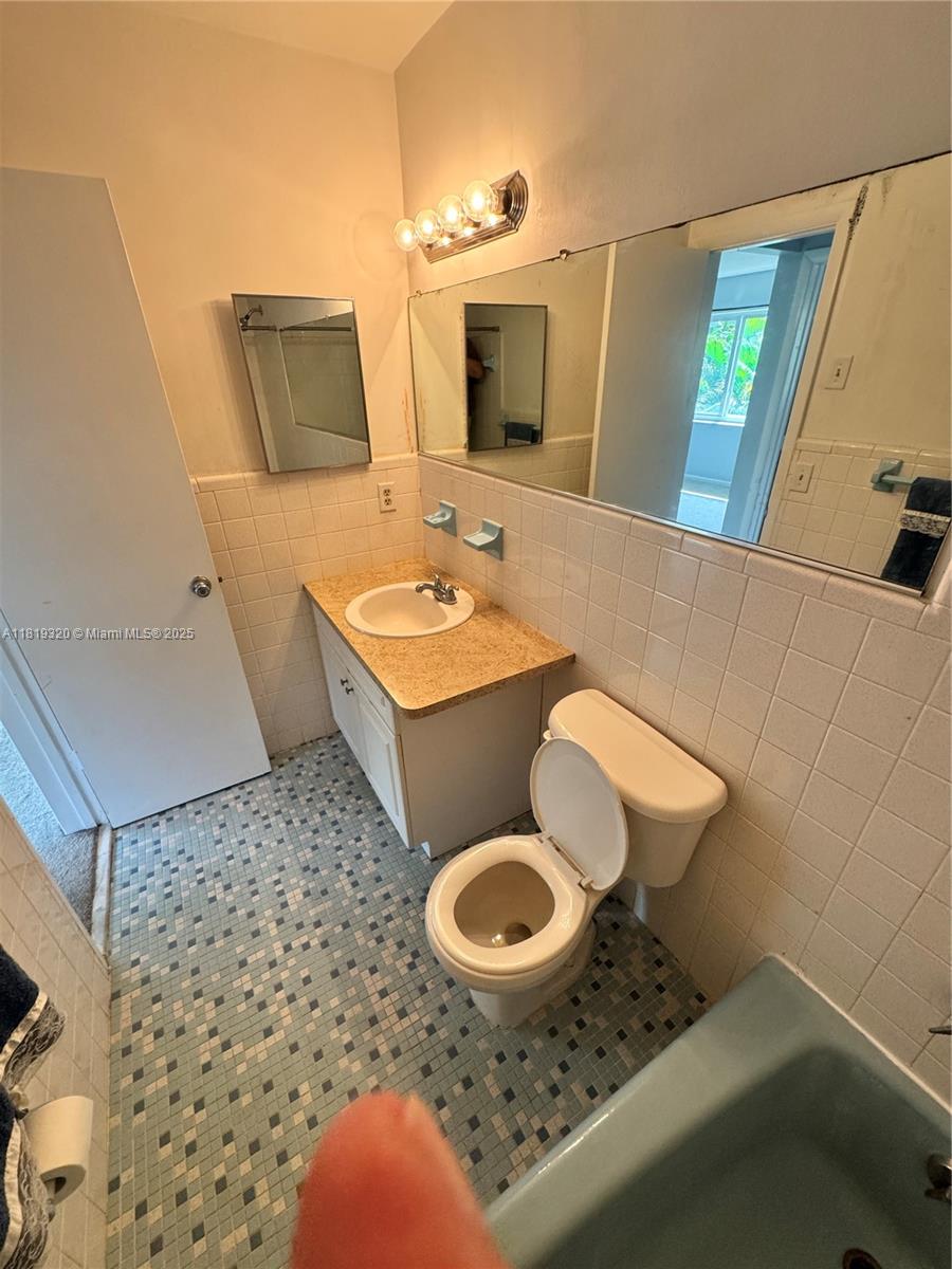 2701 Northeast 1st Street, Unit 203 Pompano Beach, FL 33062 - Photo 7 of 16 a bathroom with a sink toilet and mirror