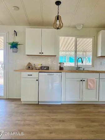 a kitchen with stainless steel appliances granite countertop a sink a stove cabinets counter space and a window