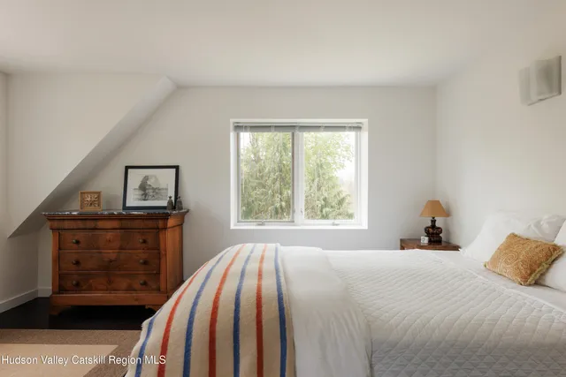 a bedroom with a bed and a large window