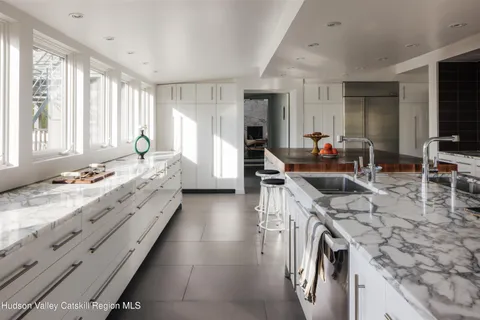 a large kitchen with kitchen island granite countertop a sink and a stove top oven