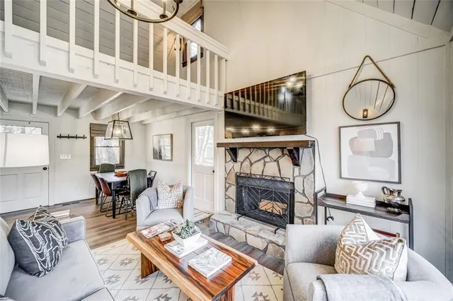 a living room with furniture a fireplace a rug and a window