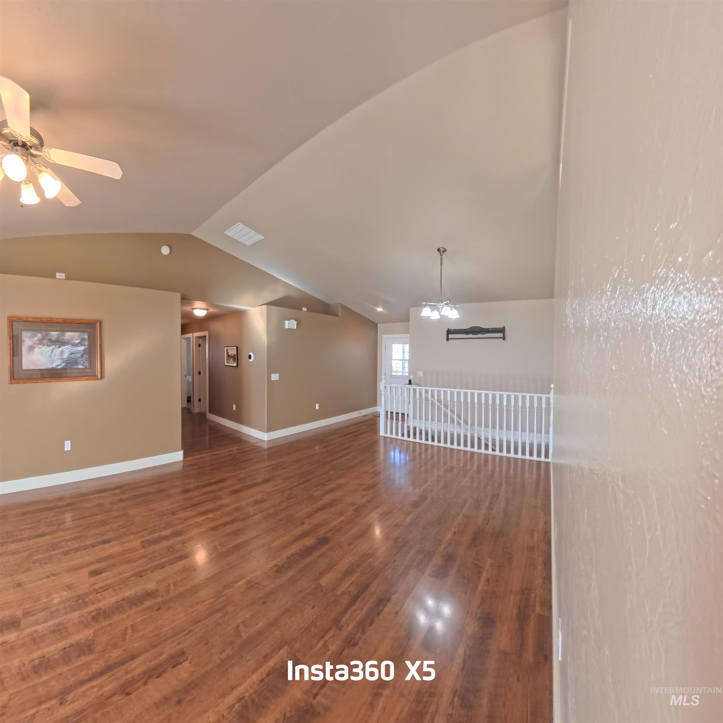 891 North Pointe Drive Twin Falls, ID 83301 - Photo 7 of 46 Unfurnished room with a chandelier, lofted ceiling, dark wood-style flooring, and ceiling fan