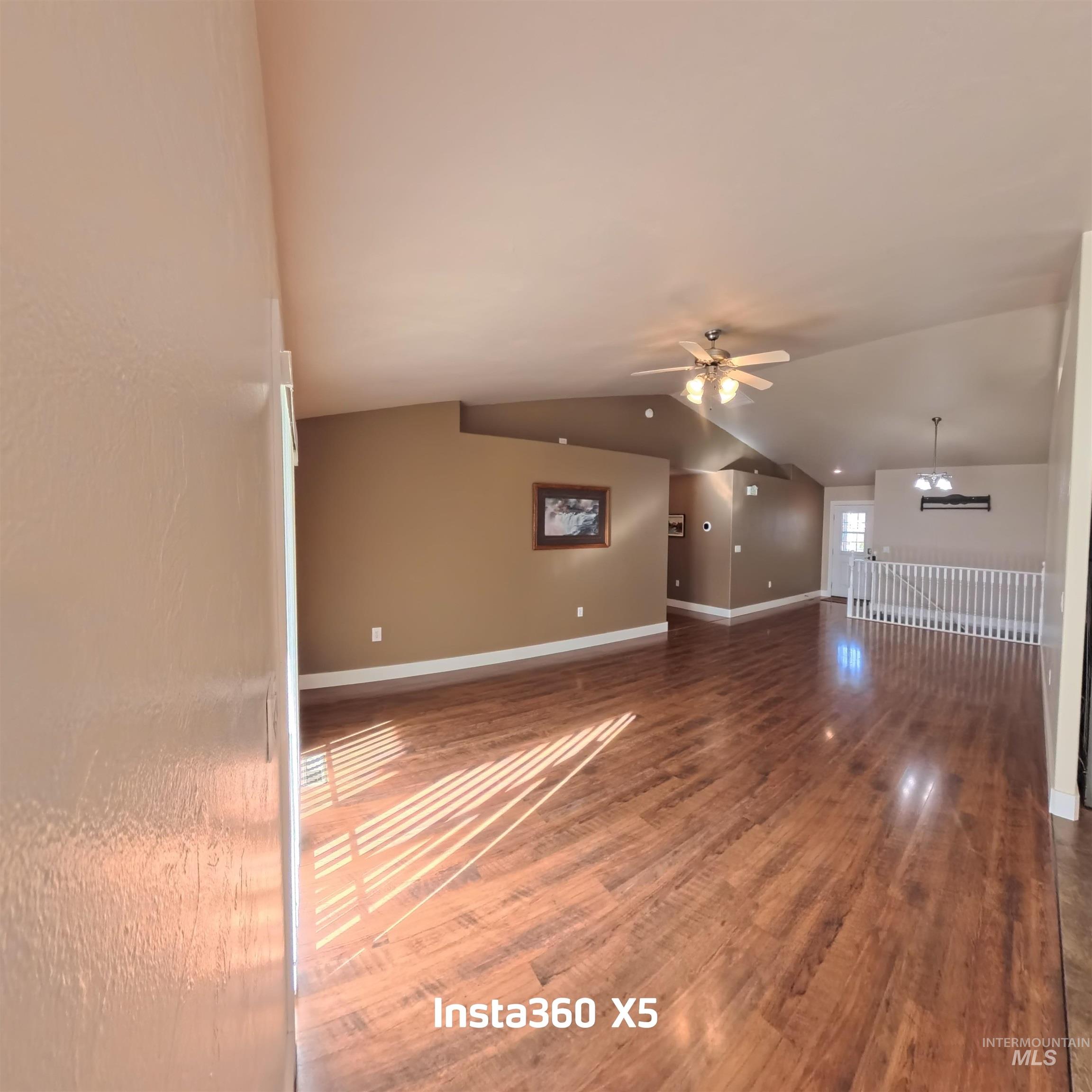 891 North Pointe Drive Twin Falls, ID 83301 - Photo 8 of 46 Unfurnished living room featuring dark wood-style flooring, lofted ceiling, and a ceiling fan