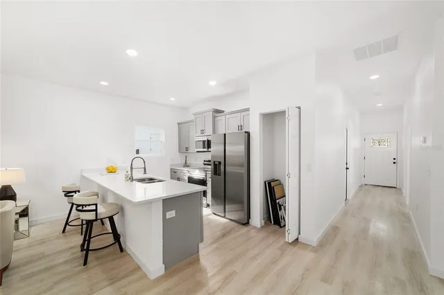 a kitchen with stainless steel appliances a refrigerator and a table
