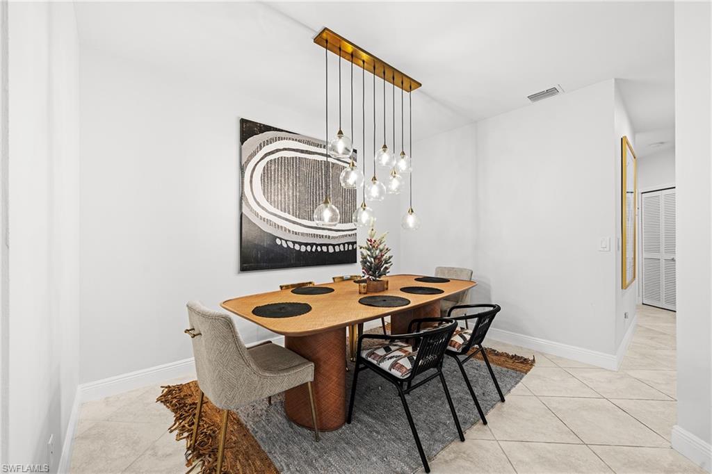 3780 Fieldstone Boulevard, Unit 301 Naples, FL 34109 - Photo 1 of 35 a table and chairs in a room