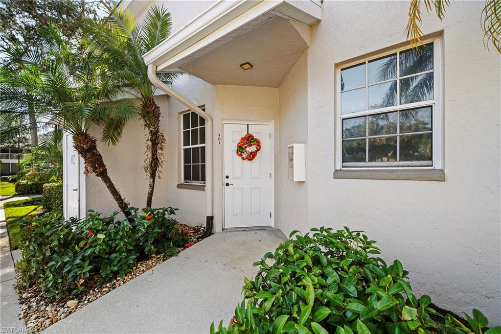 3780 Fieldstone Boulevard, Unit 301 Naples, FL 34109 - Photo 32 of 35 a front view of a house with a plants