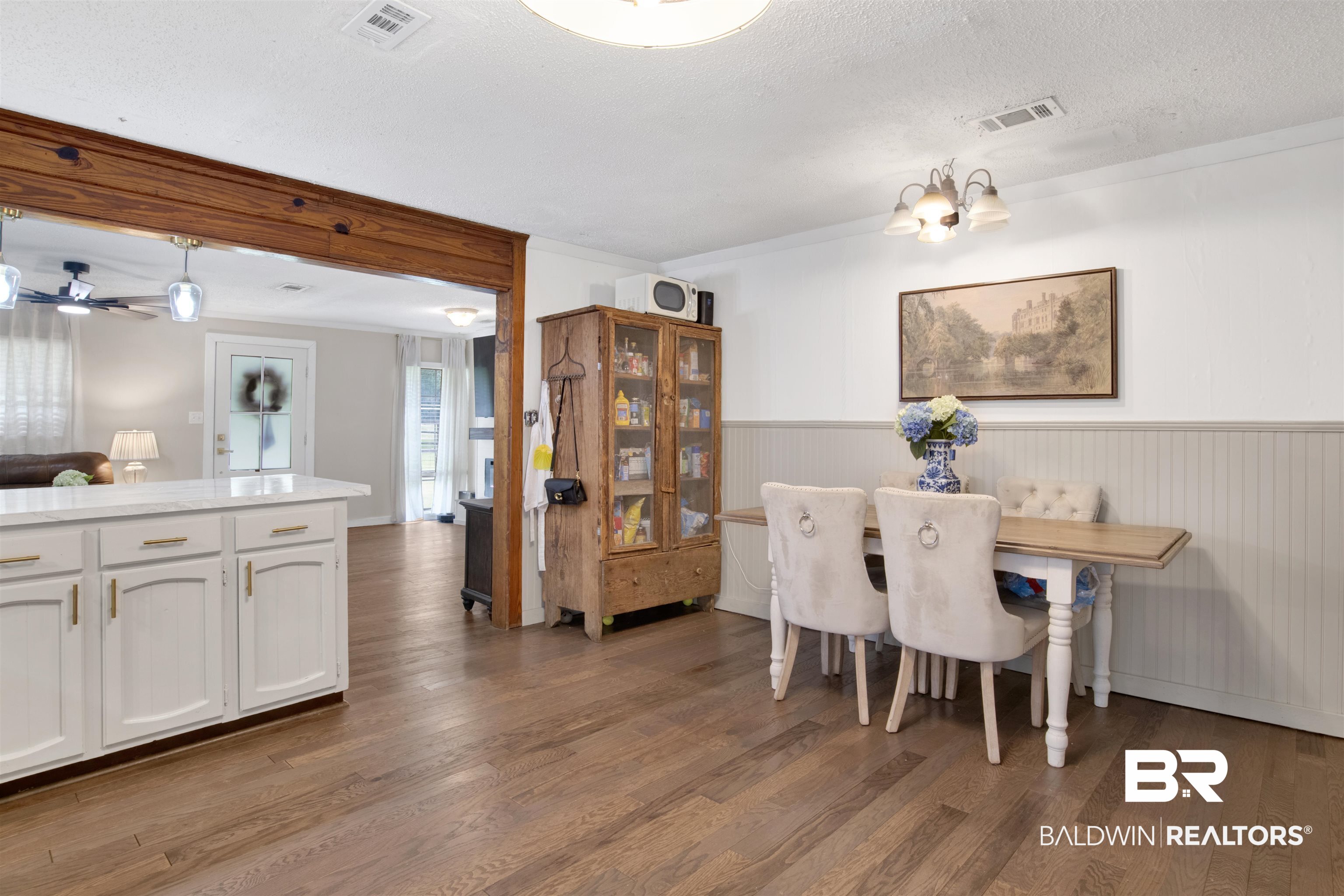 4265 Greaves Road Eight Mile, AL 36613 - Photo 12 of 34 Dining area featuring wood finished floors, wainscoting, a chandelier, and a textured ceiling