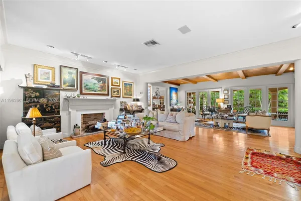 a living room with furniture fireplace and large windows