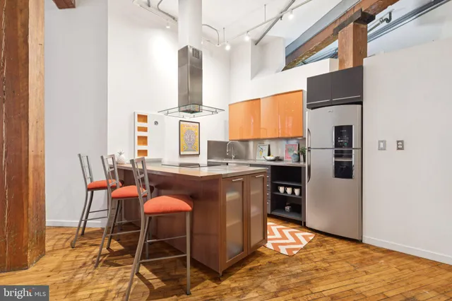 a kitchen with stainless steel appliances granite countertop a refrigerator a stove a sink and island