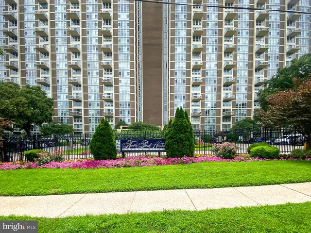 a front view of a residential apartment building with a yard and plants