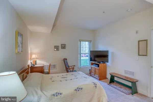 a bed room with a bed a television and a chair