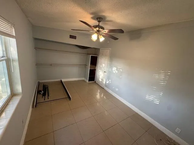 a view of a room with a ceiling fan and window