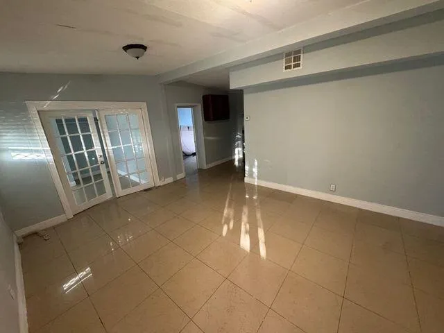 a view of an empty room with closet and a window