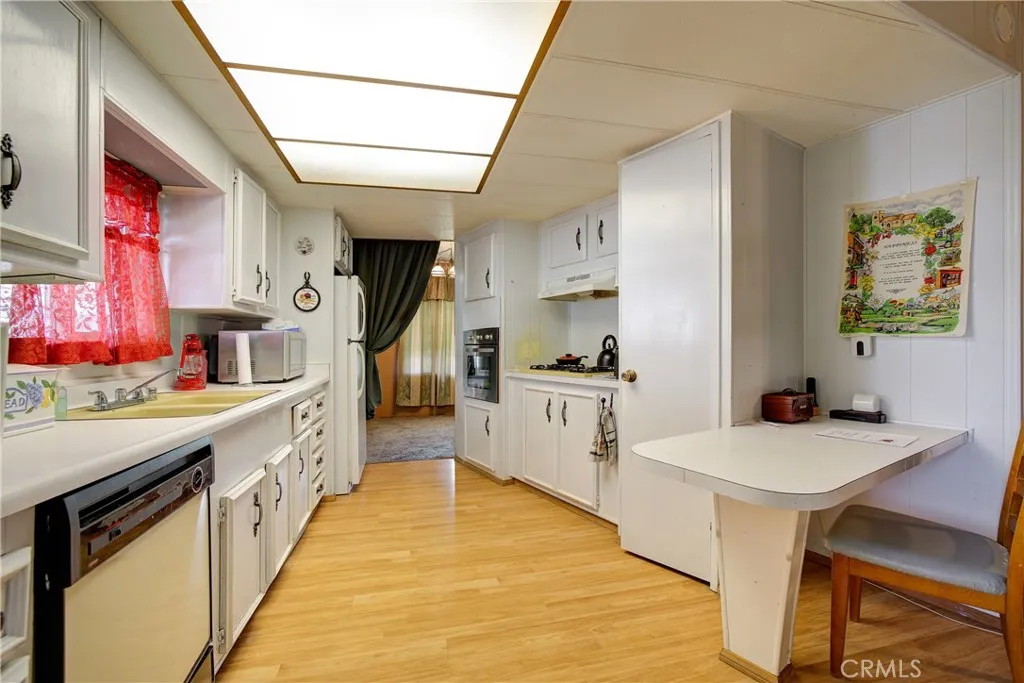 3700 Buchanan Street, Unit 105 Riverside, CA 92503 - Photo 15 of 30 a large kitchen with stainless steel appliances kitchen island granite countertop a table chairs in it and wooden floors