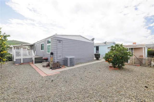 a backyard of a house with dining table and chairs