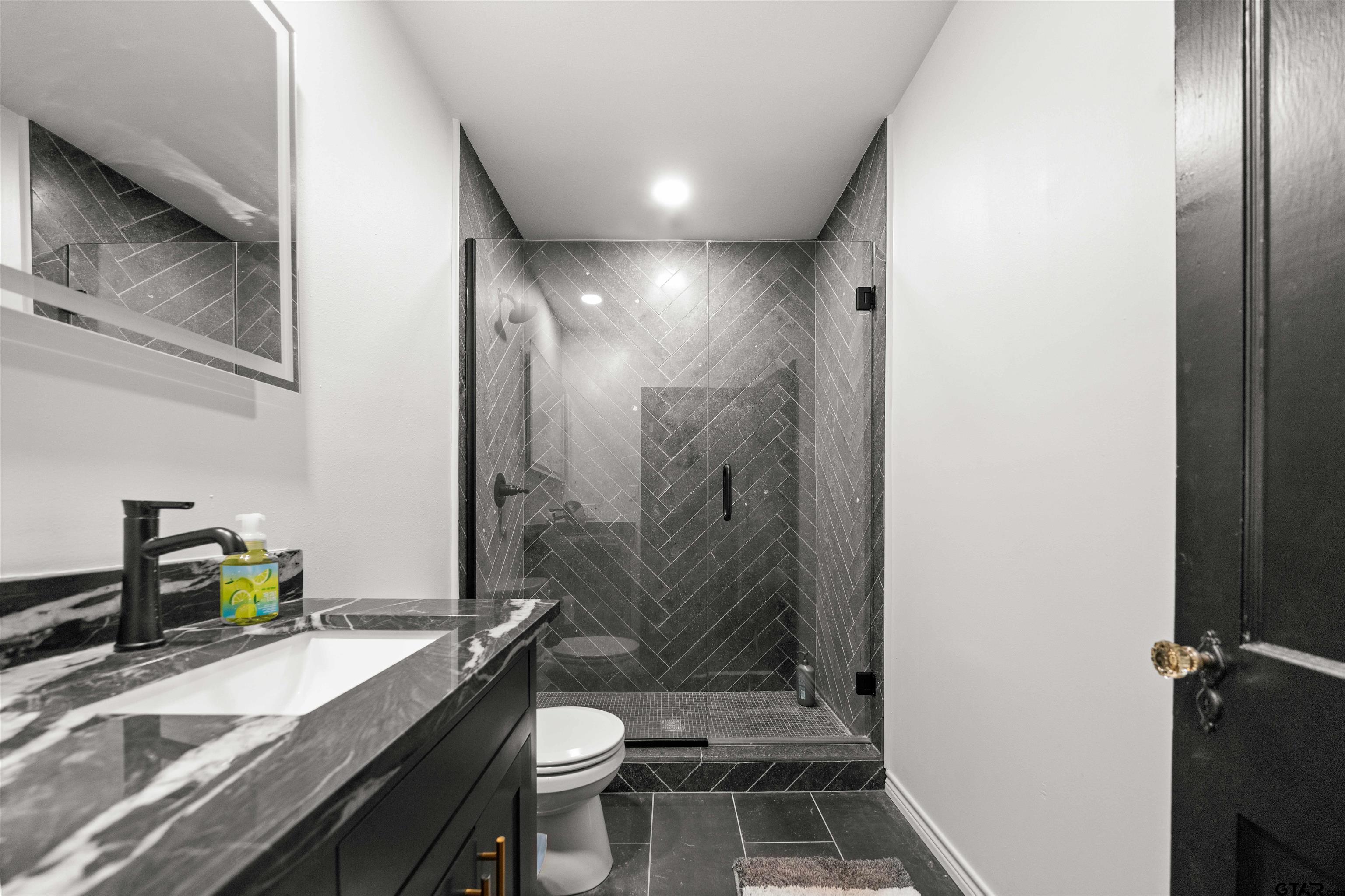 400 Lindsey Lane Tyler, TX 75701 - Photo 17 of 25 a bathroom with a granite countertop sink toilet and mirror