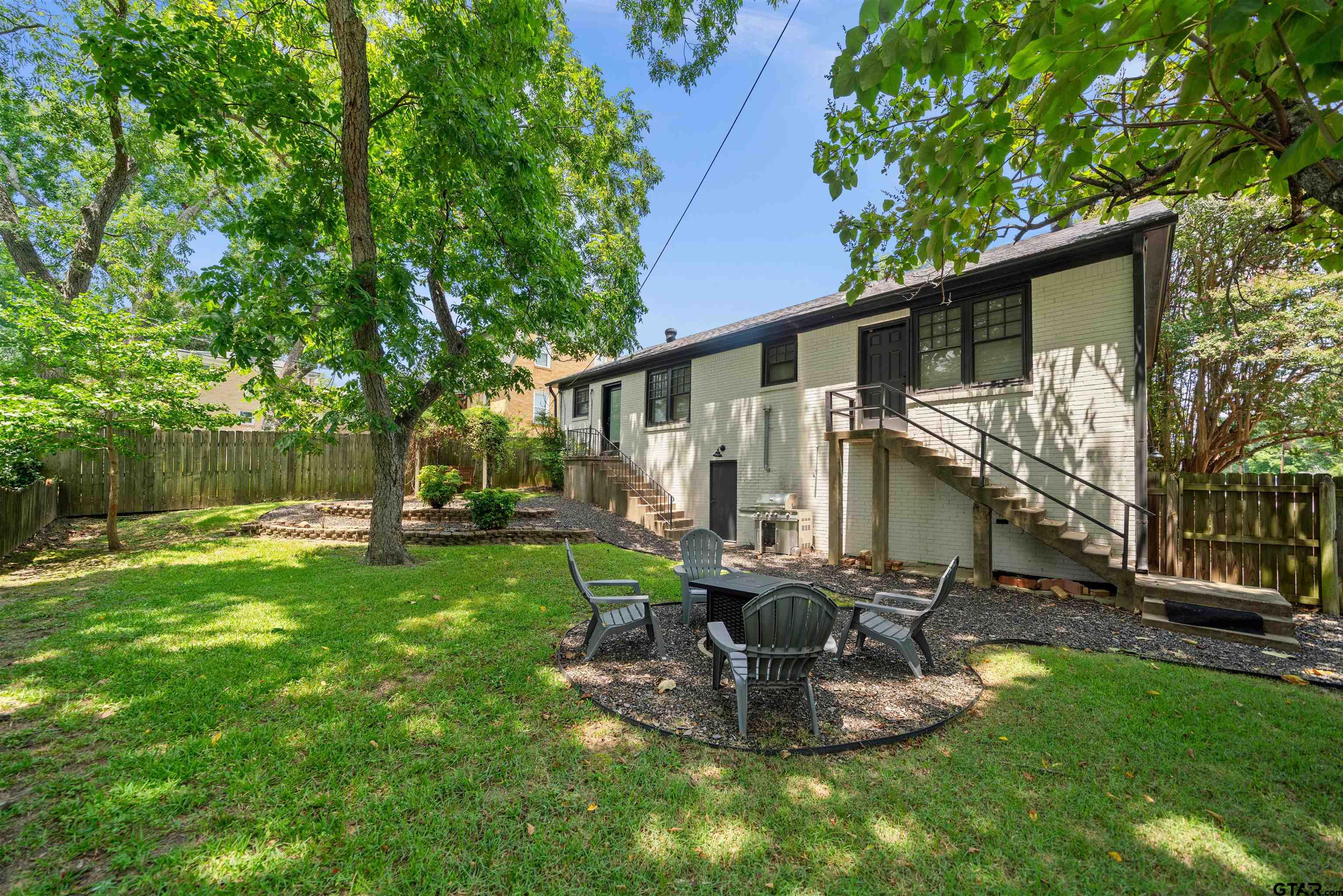 400 Lindsey Lane Tyler, TX 75701 - Photo 23 of 25 a view of a backyard with table and chairs potted plants and large tree