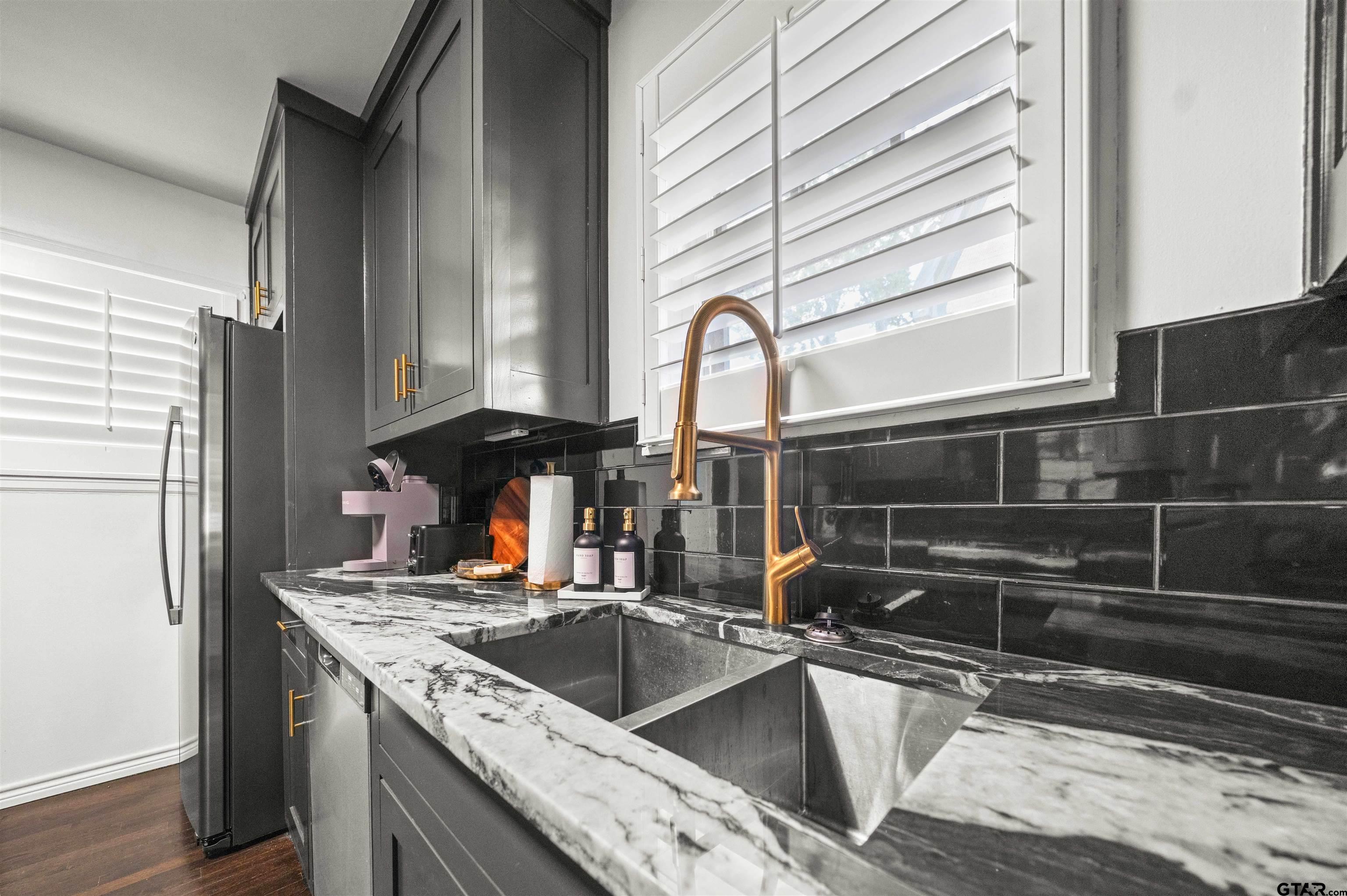 400 Lindsey Lane Tyler, TX 75701 - Photo 7 of 25 a kitchen with granite countertop a sink and a refrigerator