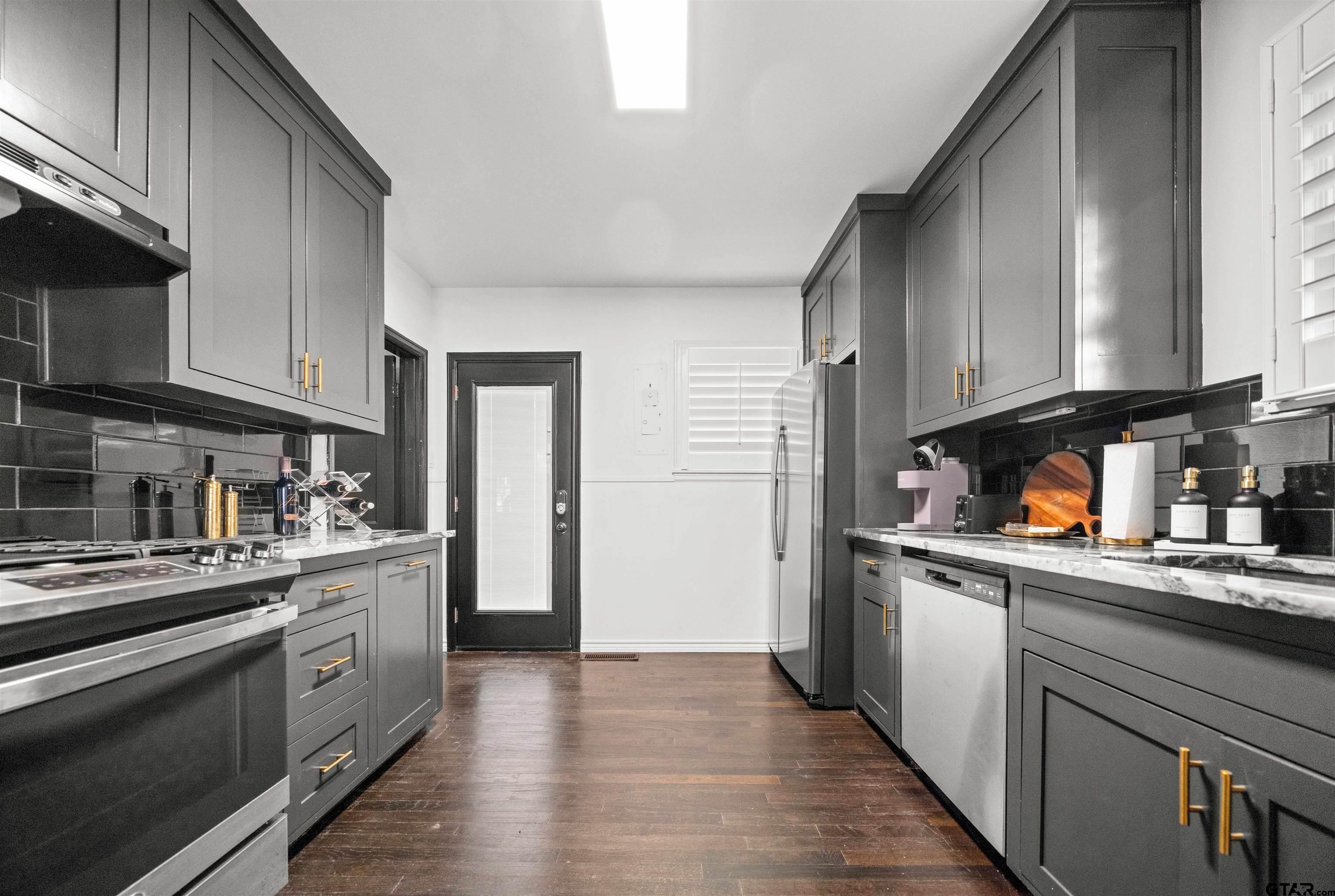 400 Lindsey Lane Tyler, TX 75701 - Photo 9 of 25 a kitchen with stainless steel appliances granite countertop a refrigerator a sink dishwasher a stove and white countertops with cabinets